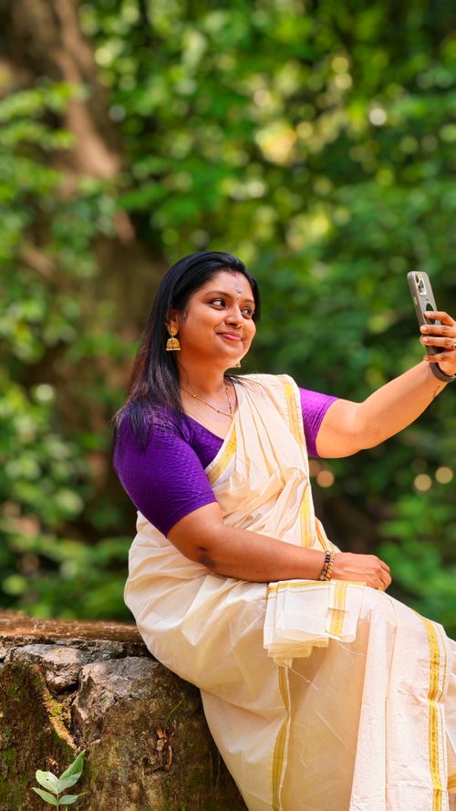 Free South Asian woman in a saree taking a selfie outdoors, blending tradition with technology. Stock Photo