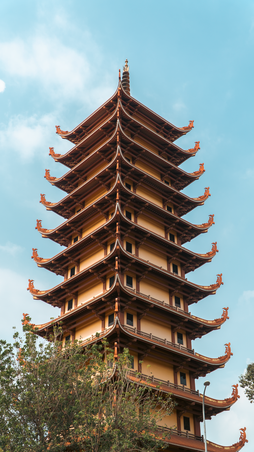 Free Tall pagoda tower with traditional architecture stands vividly against a clear blue sky. Stock Photo