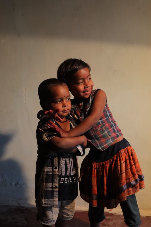 Free Two children sharing a warm embrace, capturing the essence of childhood joy in India. Stock Photo