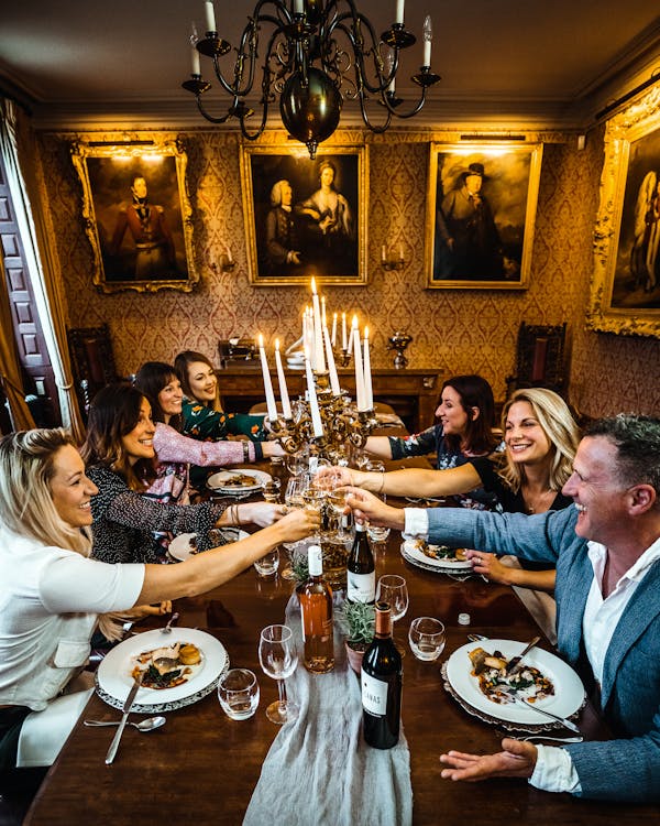 People Sitting at Dining Table with Plates and Drinks