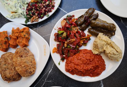 Delicious variety of Turkish meze featuring dolmas, kofte, and fresh salads.
