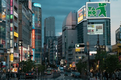 Free Evening view of a bustling urban street in Tokyo, showcasing vibrant city lights and bustling activity. Stock Photo