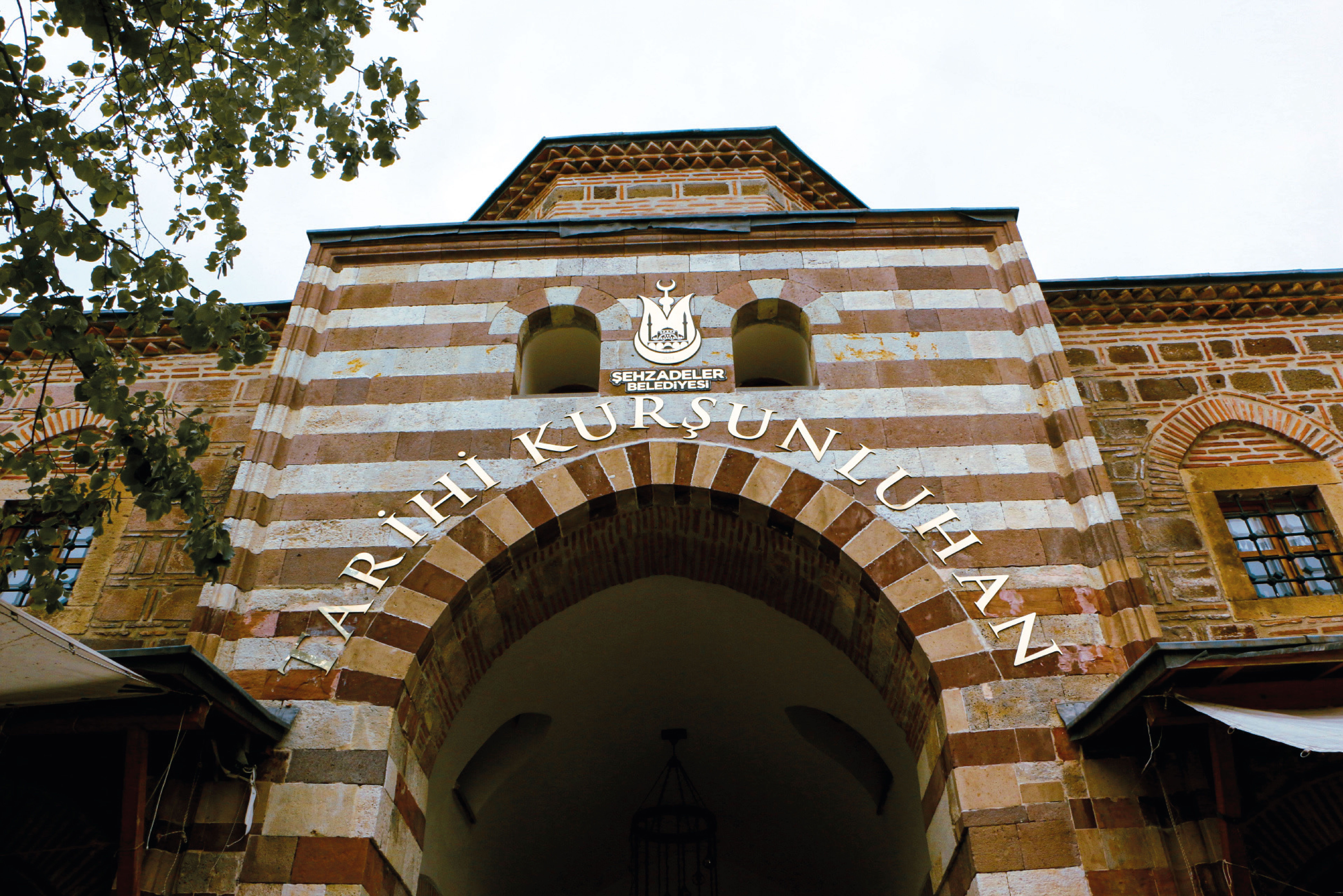 Entrance of the historic Kurşunlu Han in Manisa, Türkiye featuring traditional Ottoman architecture.