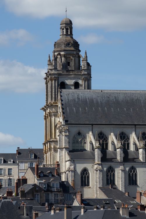 Free Stunning view of a historic cathedral tower rising above the city rooftops under a bright, clear sky. Stock Photo