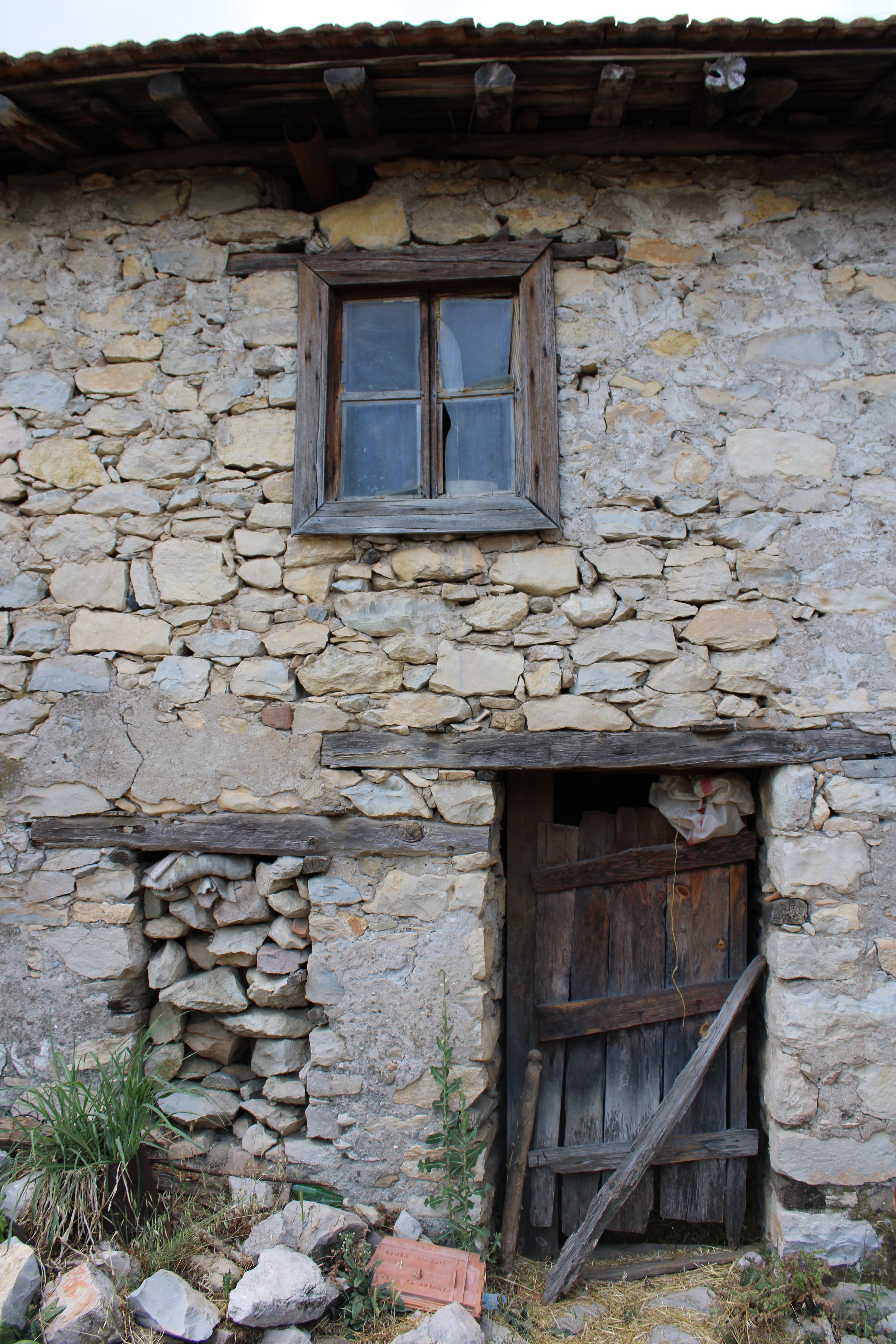 Rustic Stone House with Weathered Wooden Door · Free Stock Photo