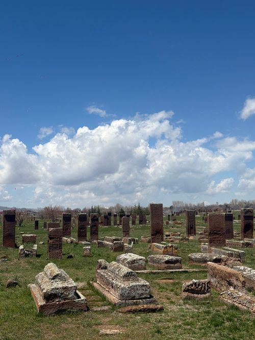Free Explore the vast historical cemetery with ancient tombstones under a serene blue sky. Perfect for history and travel themes. Stock Photo