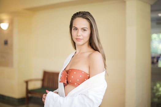 一位时尚的年轻女子在室内自信地摆着姿势，穿着别致的服装