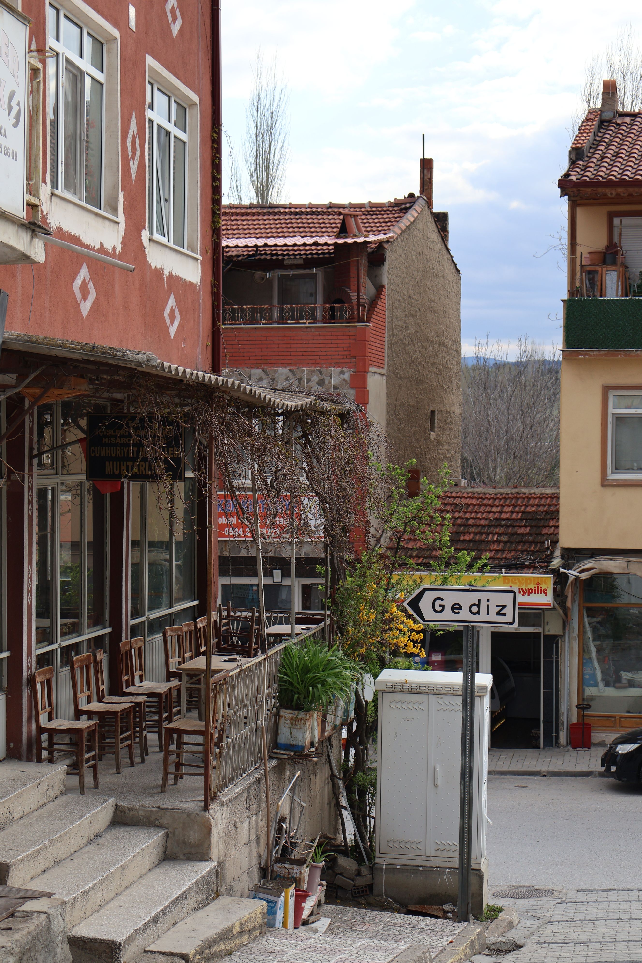 Cozy street corner in Gediz, Turkey with traditional architecture and inviting outdoor seating.