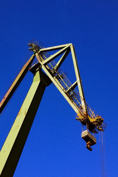 Free Steel shipyard crane against a clear blue sky in Gdańsk, Poland. Stock Photo