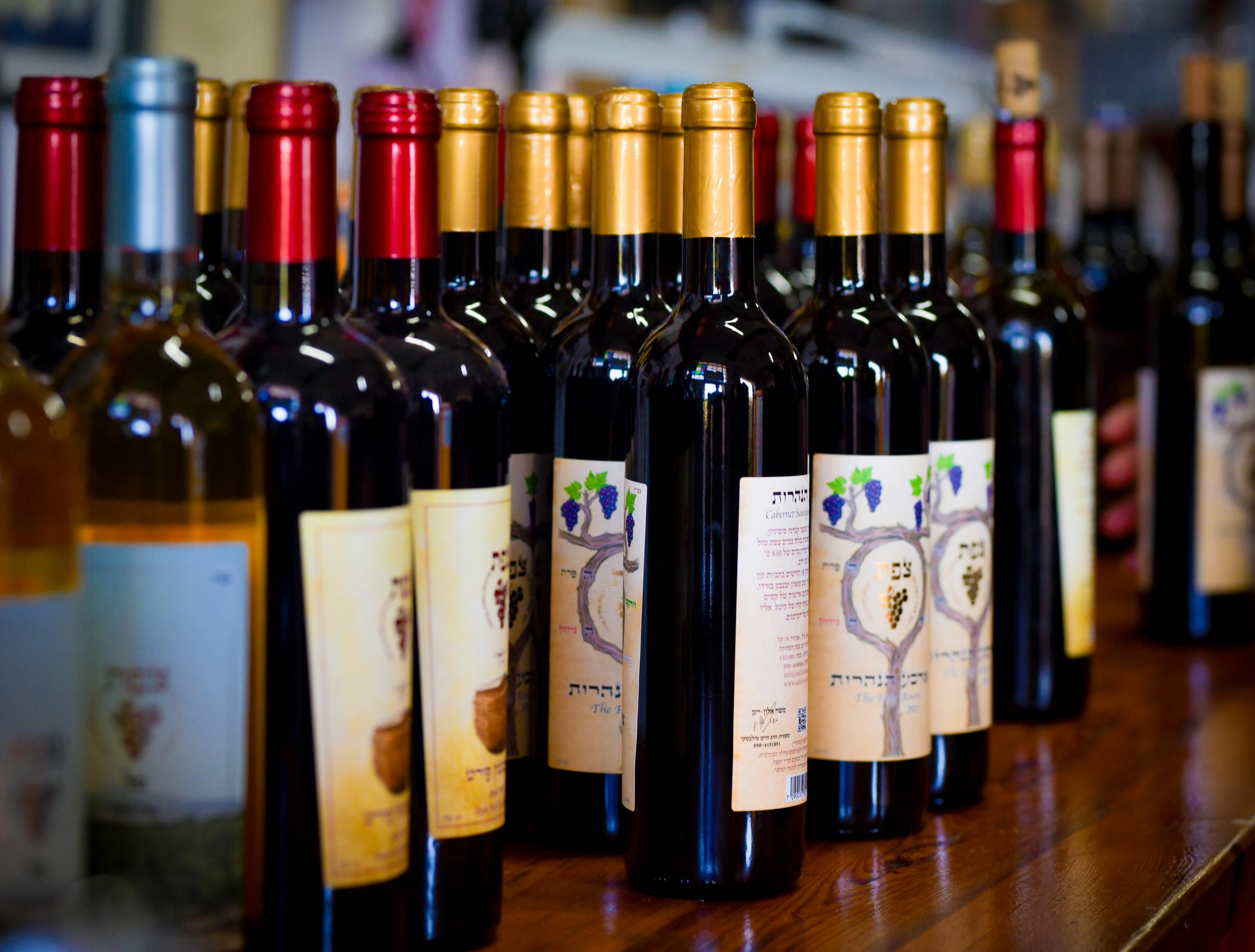 Close-up of assorted wine bottles on display at a winery showcasing various labels and colors.
