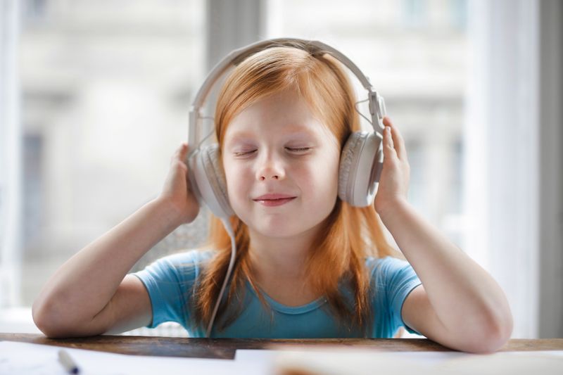 A young girl with headphones enjoying music