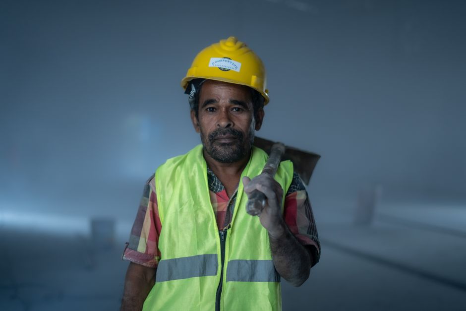 Portrait of a construction worker in safety gear at an industrial site, conveying hard work and determination.