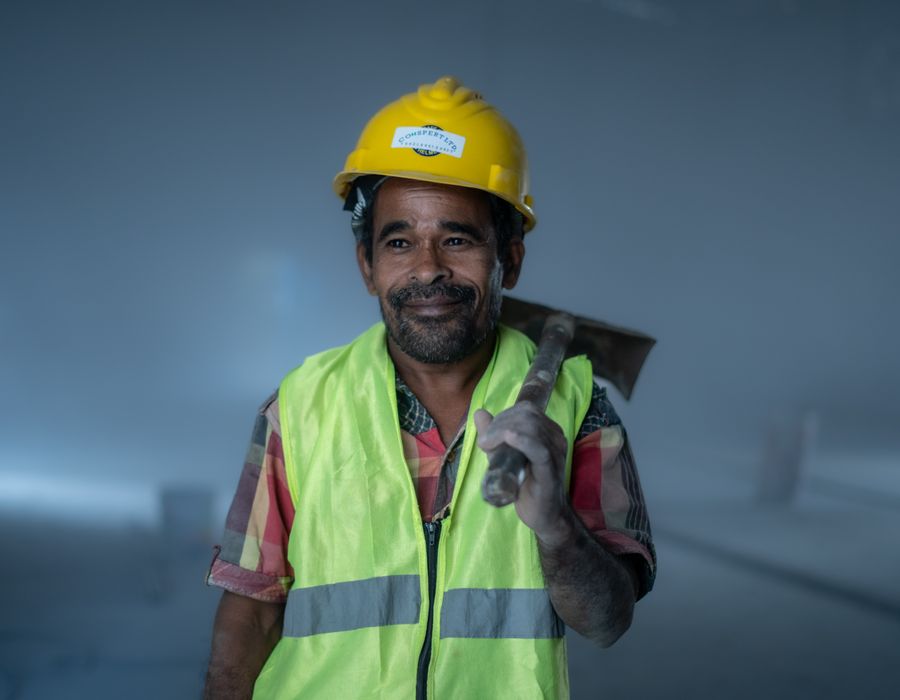 Profissional da construção civil com capacete e ferramenta