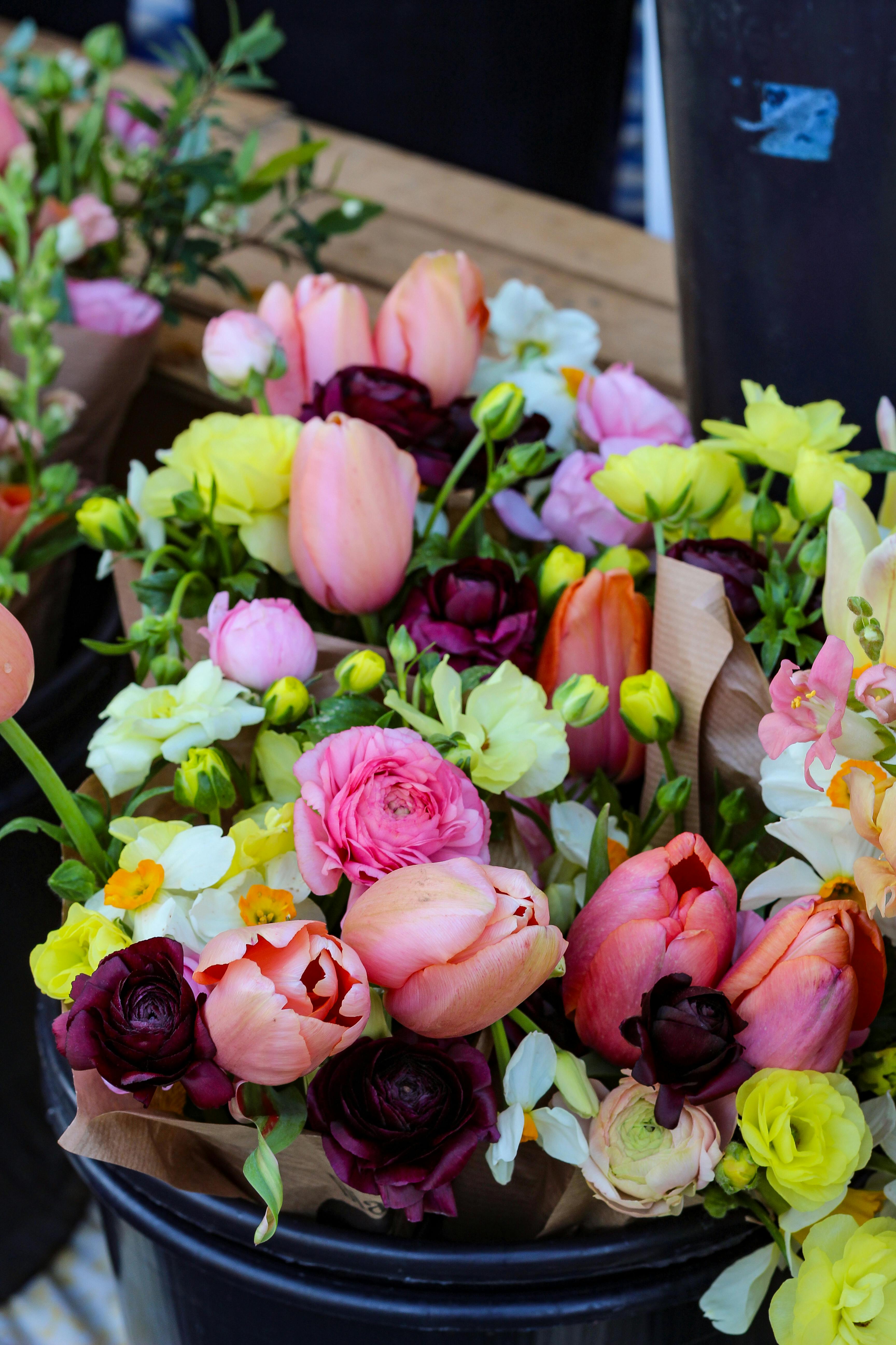 [ColoSach]-a-colorful-mixed-flower-bouquet-featuring-tulips,-roses,-and-more-in-a-market-setting.
