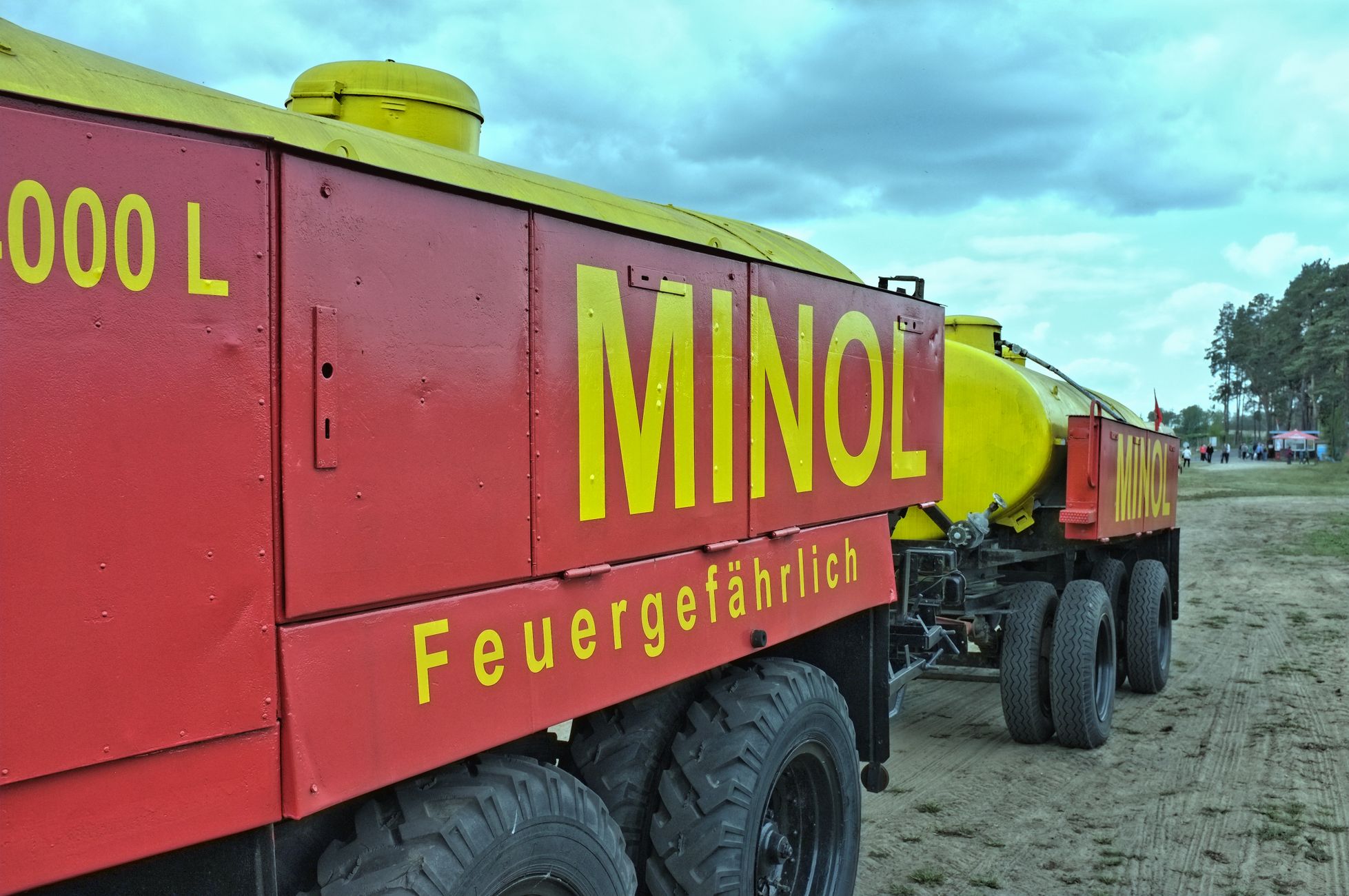 Sproeiwagen geeft water aan bomen tijdens regenval