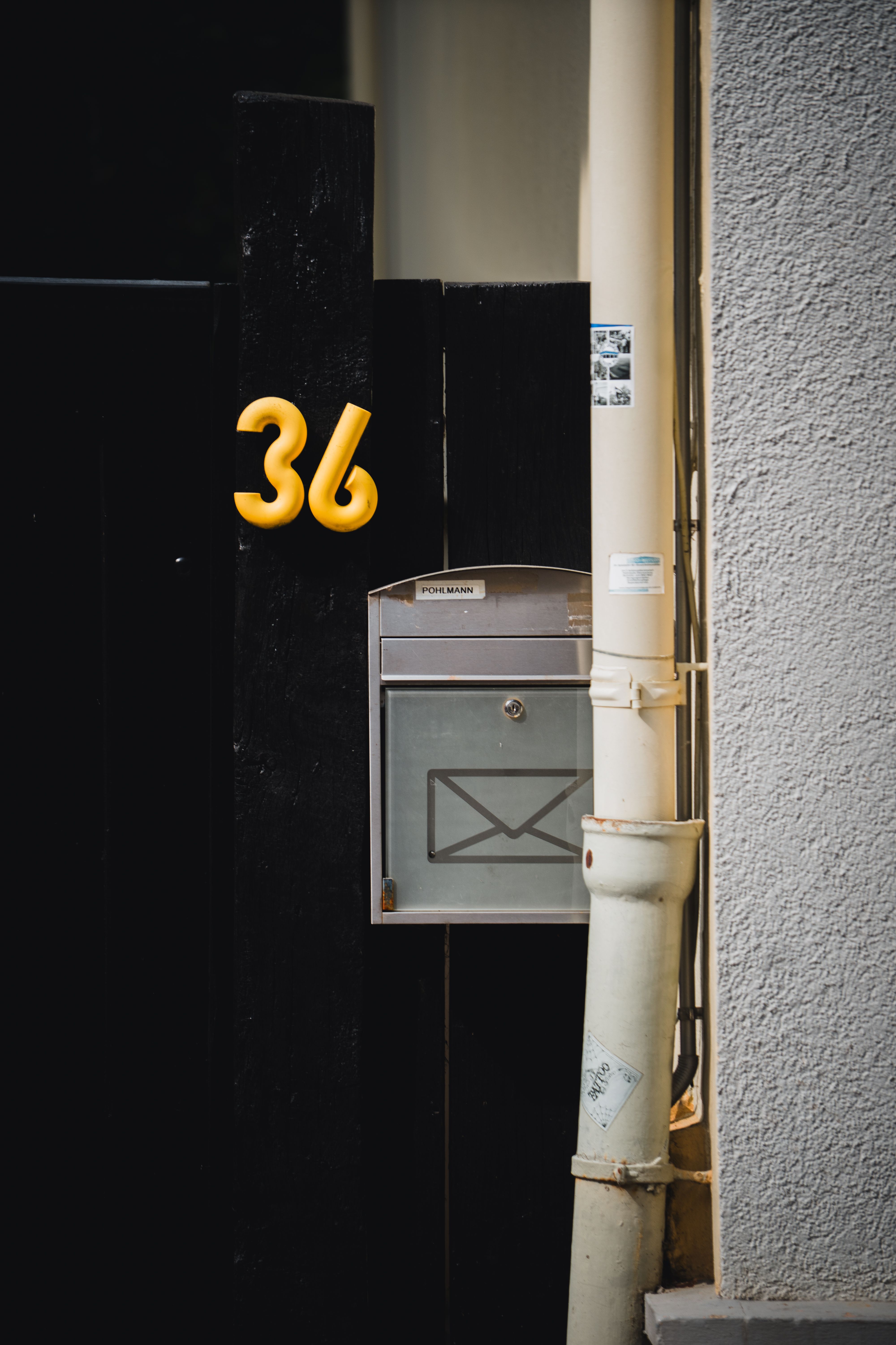 Close-up of a house entrance featuring a silver mailbox and a bold yellow number 36 in Lemgo, Germany.