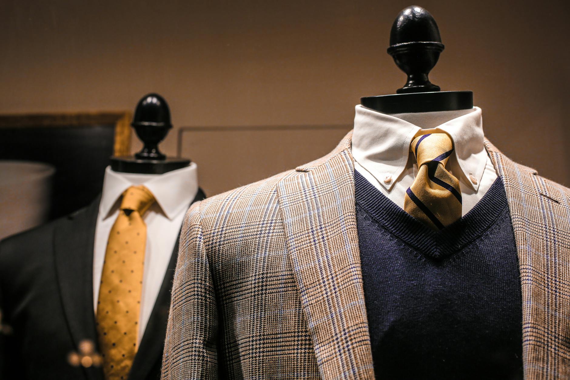 Dandy fancy jackets with shiny ties on dummies in showroom of contemporary male shop