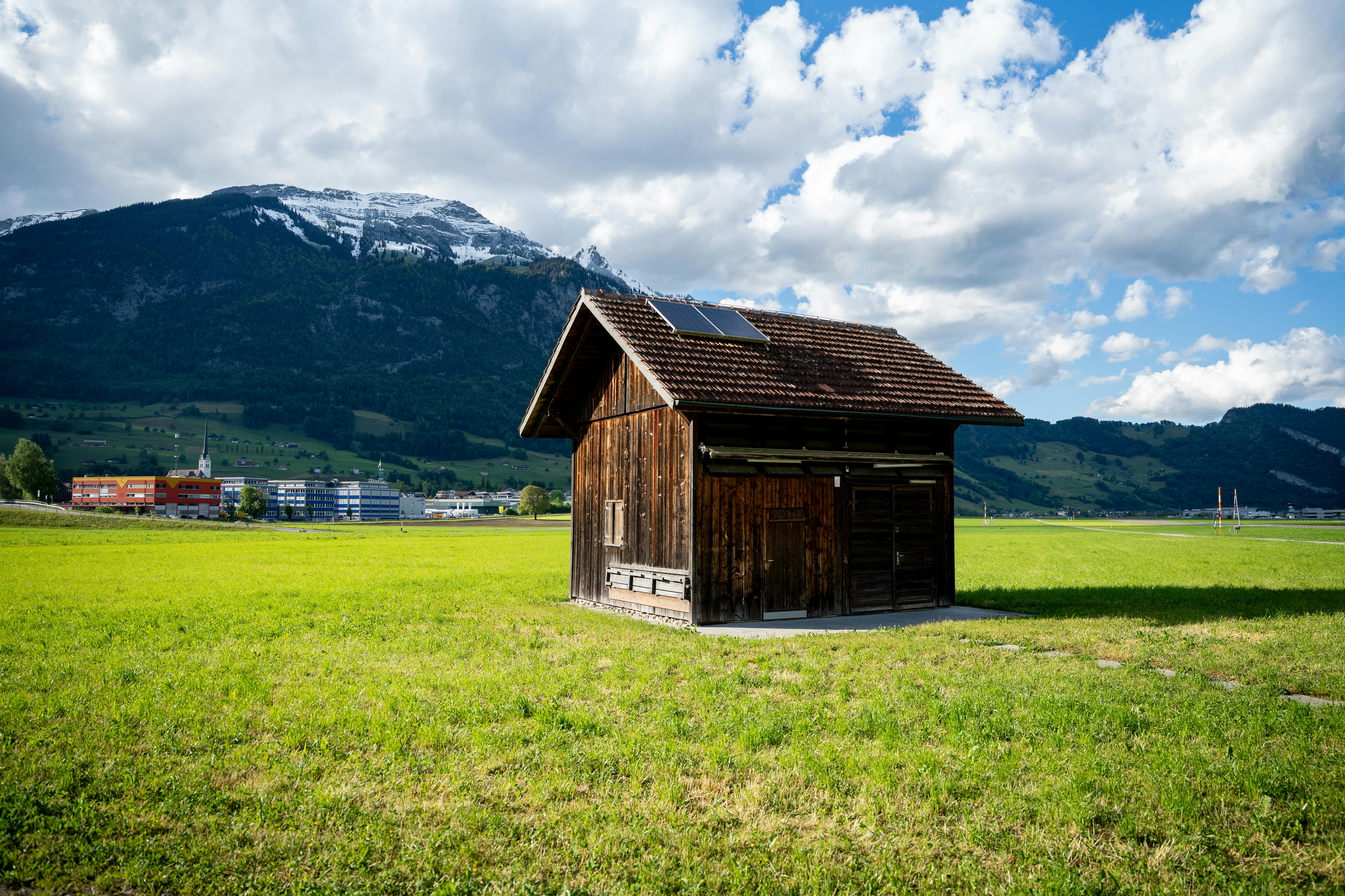 Charmant chalet en bois sur un champ verdoyant avec de superbes montagnes, Alpnach, Suisse.