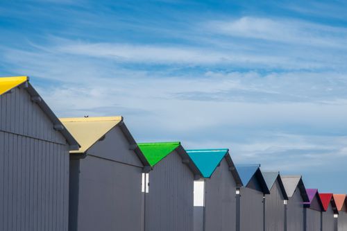 Free A vibrant lineup of colorful beach huts under a blue sky at Criel-sur-Mer, Normandie. Stock Photo