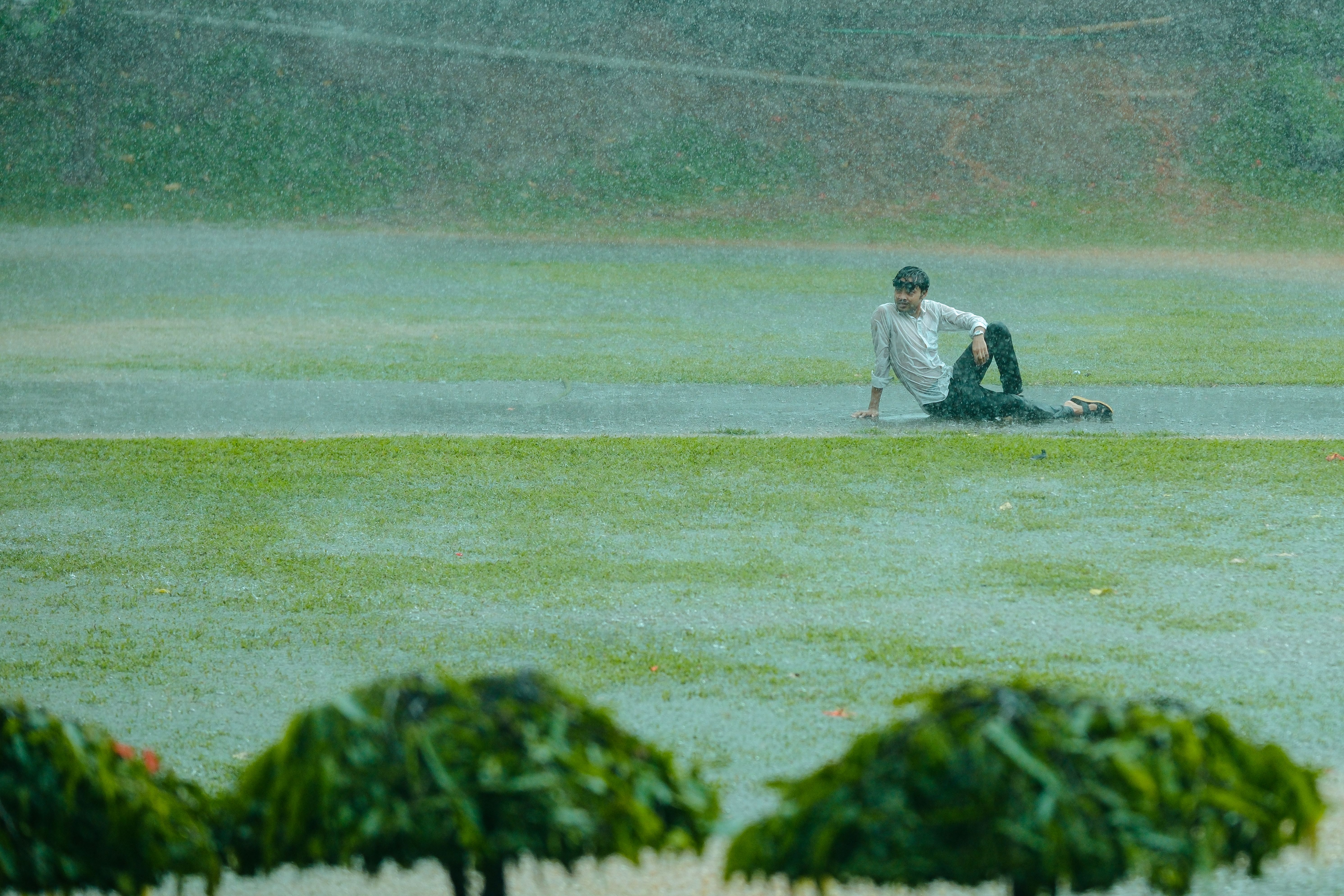 Rain-soaked Sha Tin racecourse with officials inspecting the turf