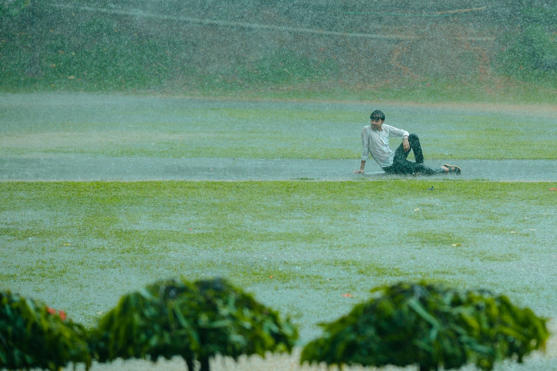 Rain-soaked Sha Tin racecourse with officials inspecting the turf