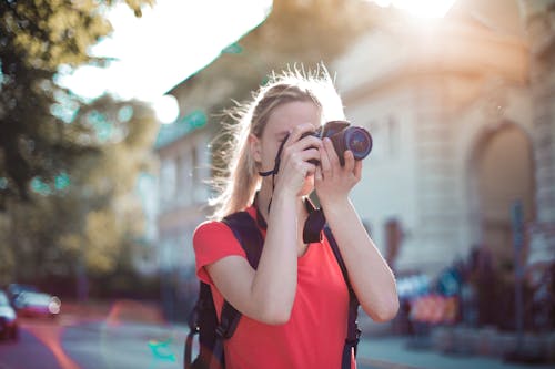 Woman in Red Shirt Taking Pictures Using Dslr camera