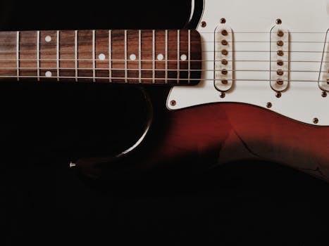 Detailed shot of an electric guitar with a dark background emphasizing the instrument's features.