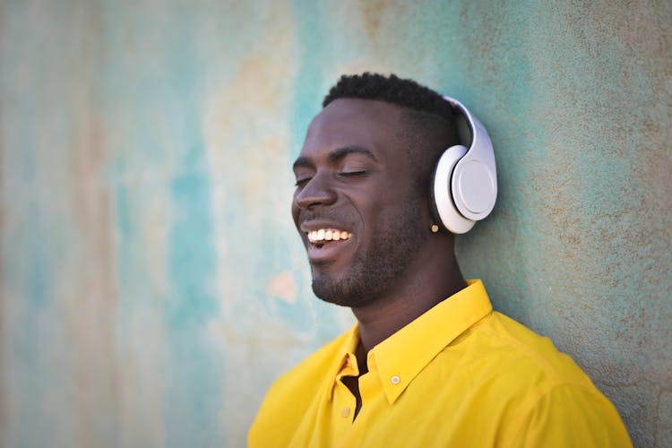 Man In Yellow Polo Shirt Wearing White Headphone