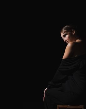 Low-key portrait of a woman in dark attire with dramatic lighting.. portrait, woman, dark