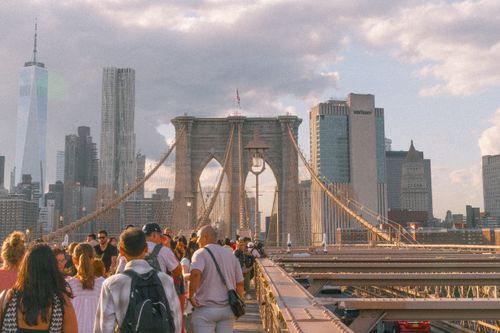 Free A vibrant sunset view of the Brooklyn Bridge with people enjoying the iconic skyline of New York City. Stock Photo