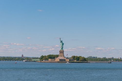 Free A scenic view of the iconic Statue of Liberty under a clear blue sky, New York City. Stock Photo