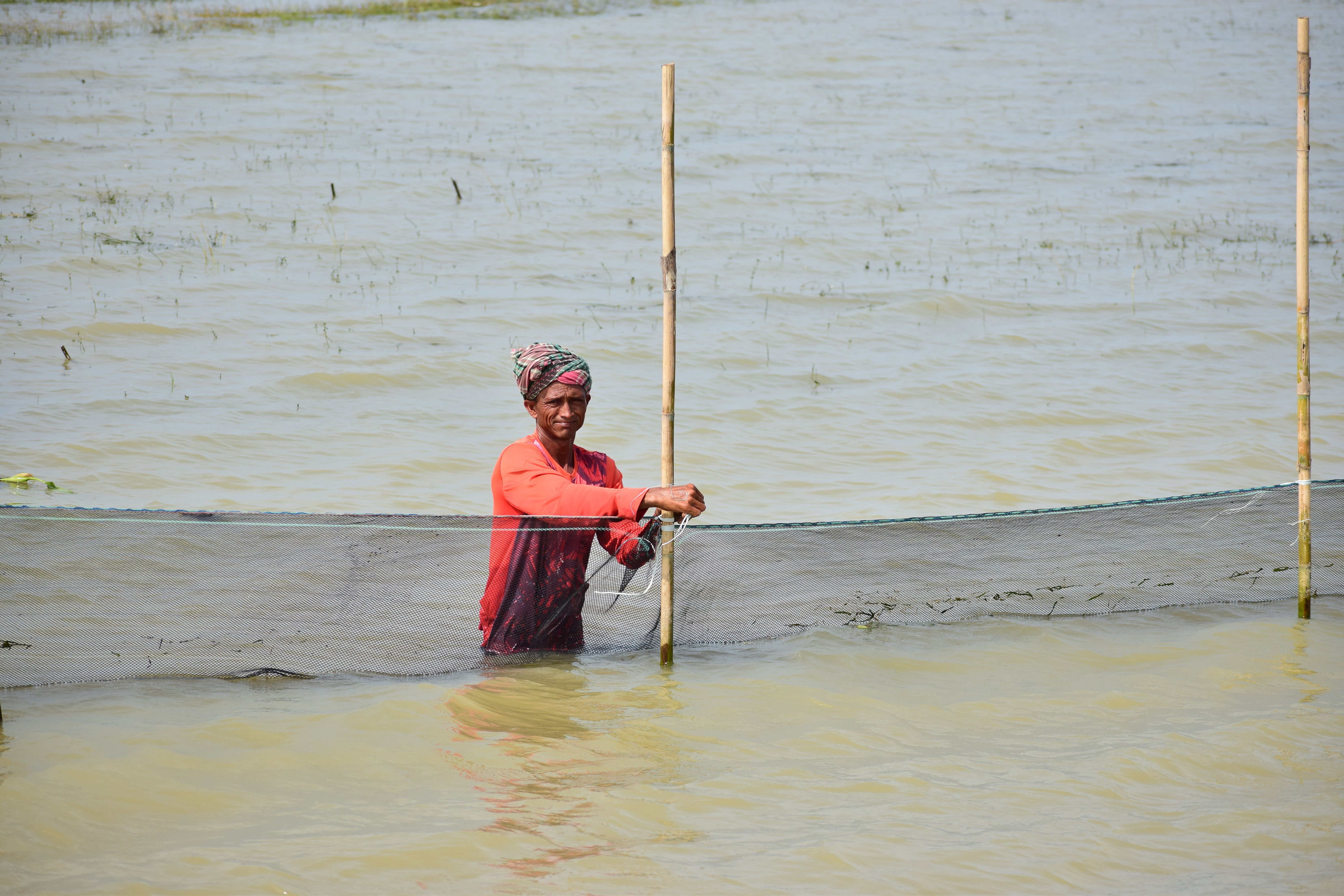 Local fisherman setting nets in a river in Dhaka Division, capturing daily life.