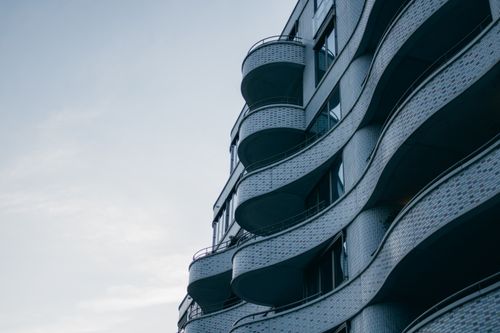 Free Captivating architectural design with unique curved facade and balconies against a clear sky. Stock Photo