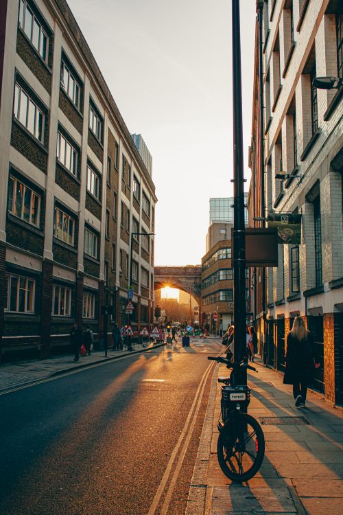 Free Bicycle parked on a city street at sunset, capturing urban life and architecture. Stock Photo
