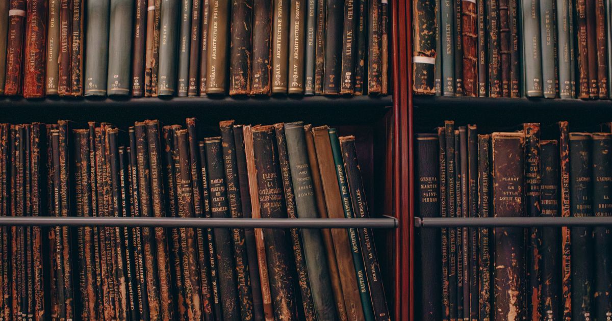 Vintage library books on wooden shelves, representing the century-old origin of Wyckoff accumulation theory