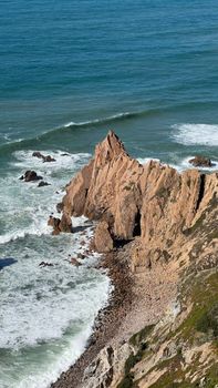 Breathtaking aerial view of rugged coastal cliffs meeting the Atlantic Ocean in Portugal.