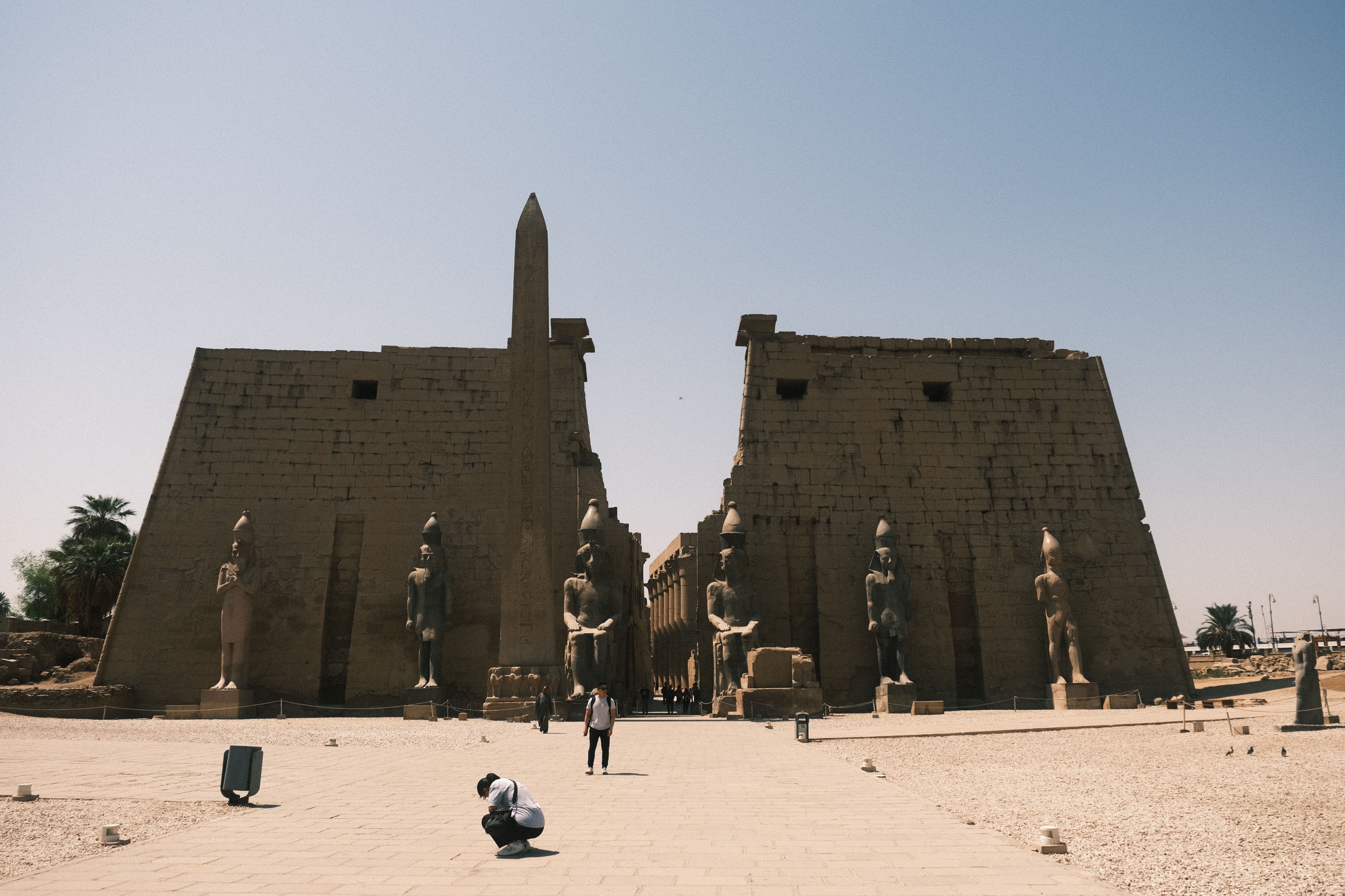 Frau mit Kopftuch geht in der goldenen Stunde an der Corniche in Luxor entlang