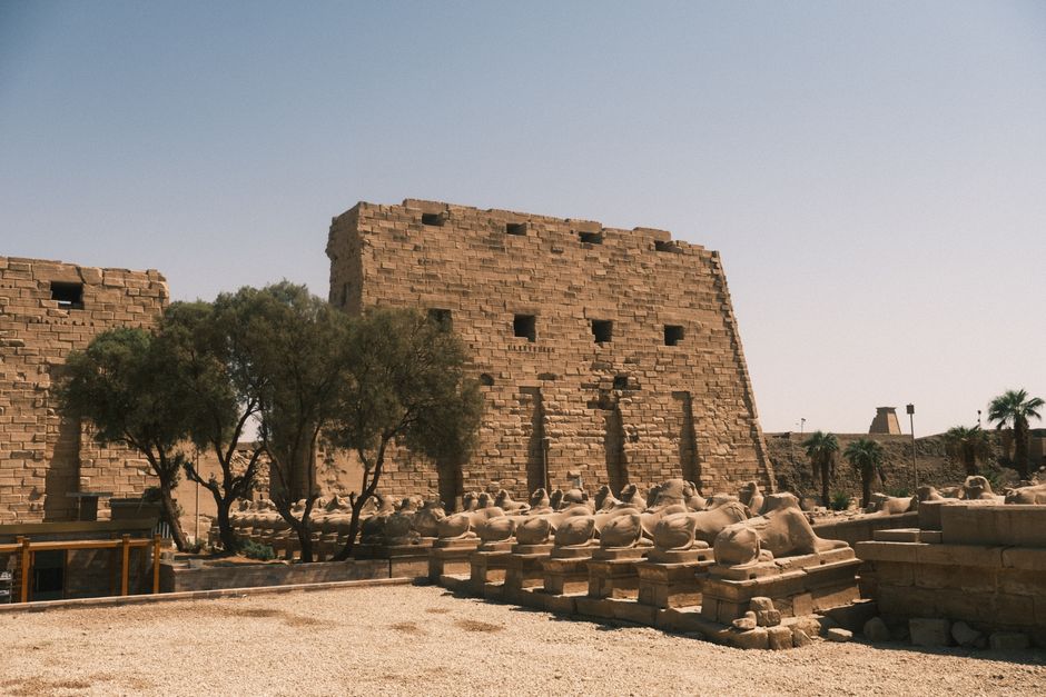 View of the ancient ruins at Karnak Temple, Luxor, showcasing historic Egyptian architecture under a clear summer sky.