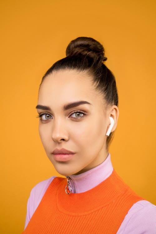 Woman in Knitted Turtleneck Shirt in Orange Background