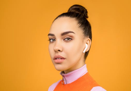 一位戴着耳机的时尚年轻女子在工作室里，以亮黄色背景摆出姿势