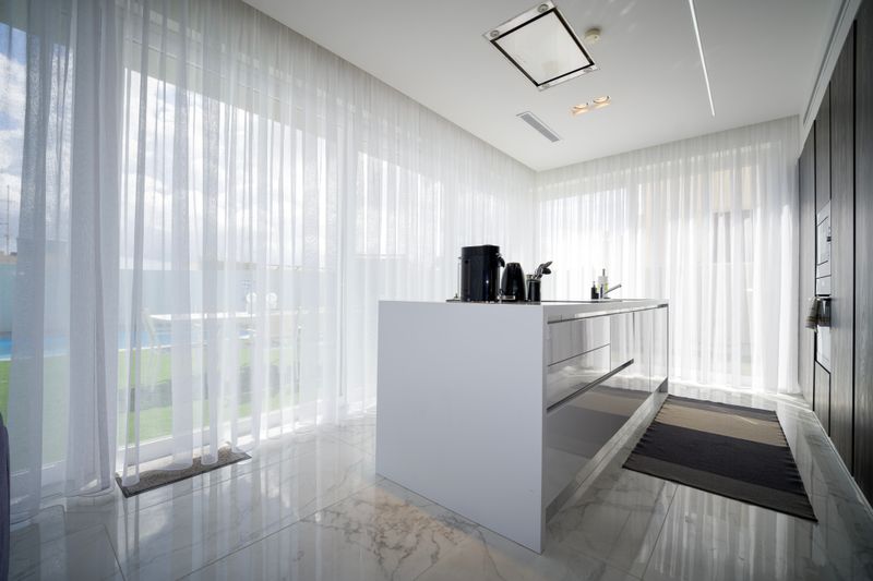 Bright modern kitchen in a St Julian's villa in Malta, where oven, fridge and cabinet extras add time to a clean