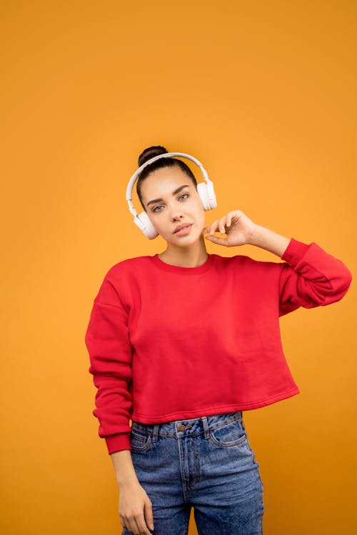 Girl in Red Crop Top Wearing White Headphones