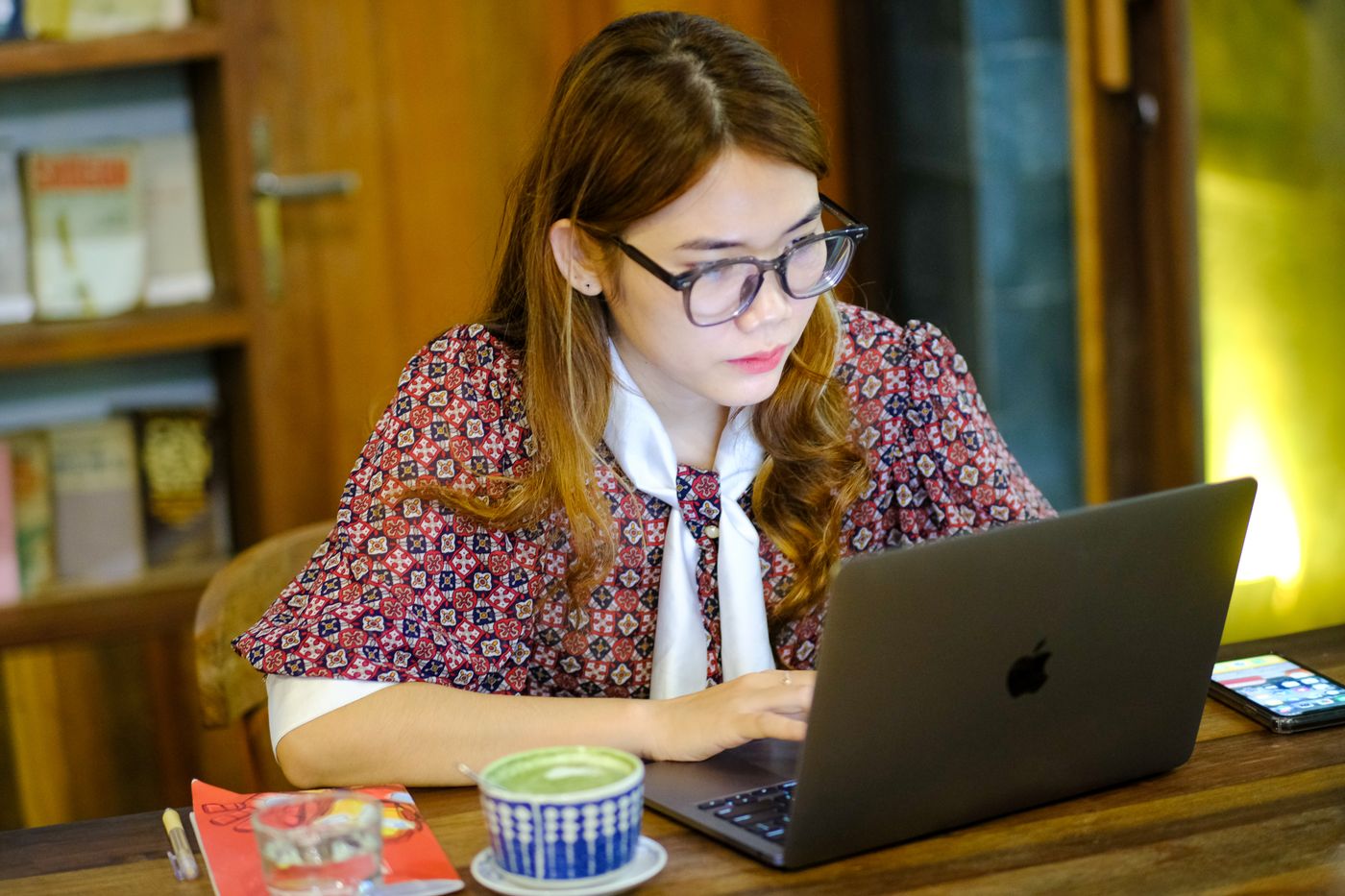 Người phụ nữ Việt làm việc với laptop trong quán cà phê