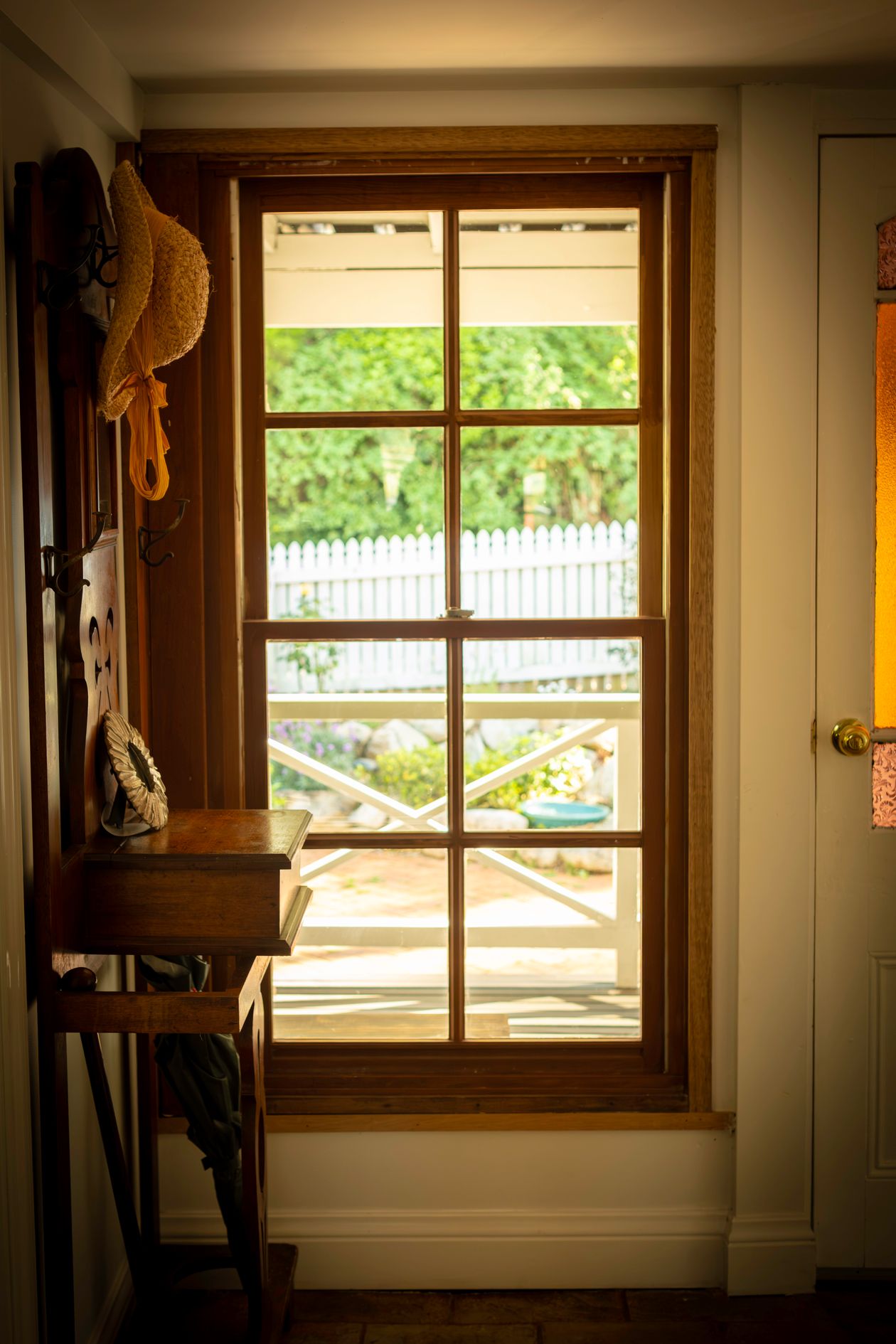 Warm vintage mudroom with a sunny window and neatly organized hooks
