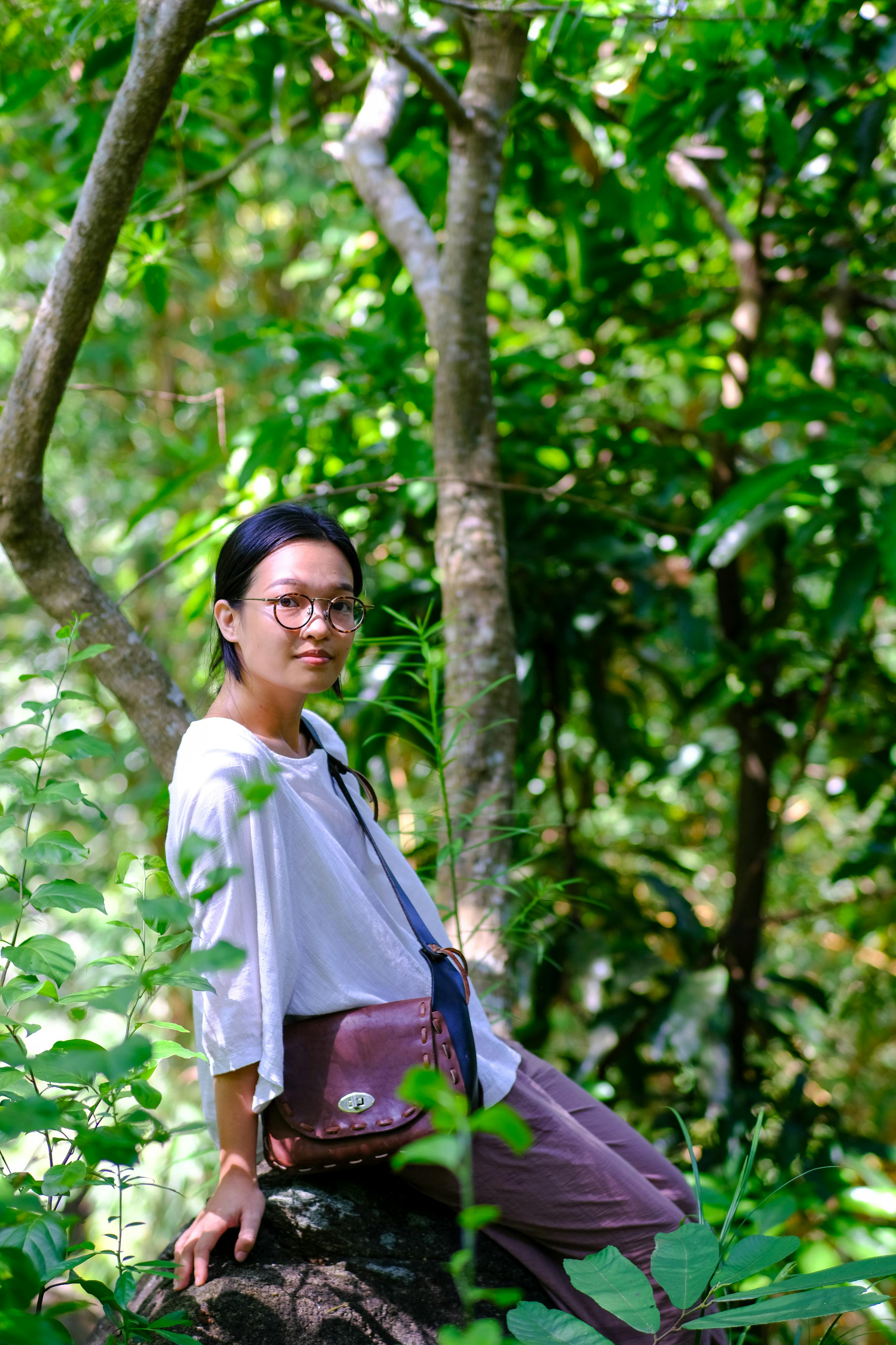 Portrait of a woman in Da Nang, Vietnam, immersed in a lush forest setting.