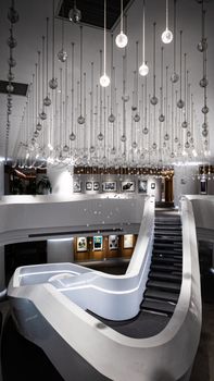 Elegant interior showcasing a spiral staircase with modern lighting in a minimalist design.