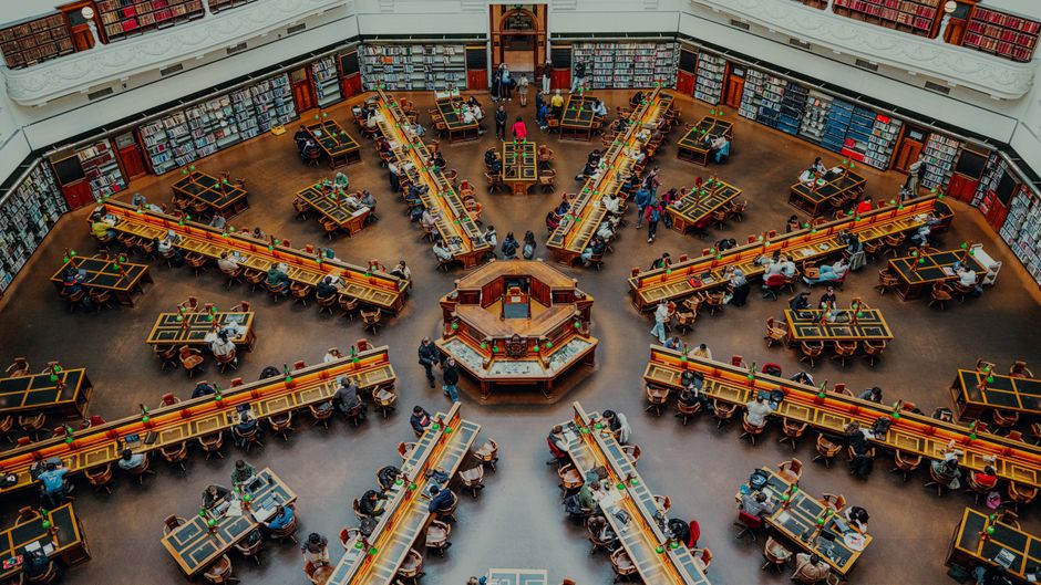 A vibrant study area within a grand library captured from above, showcasing architectural beauty and student life.