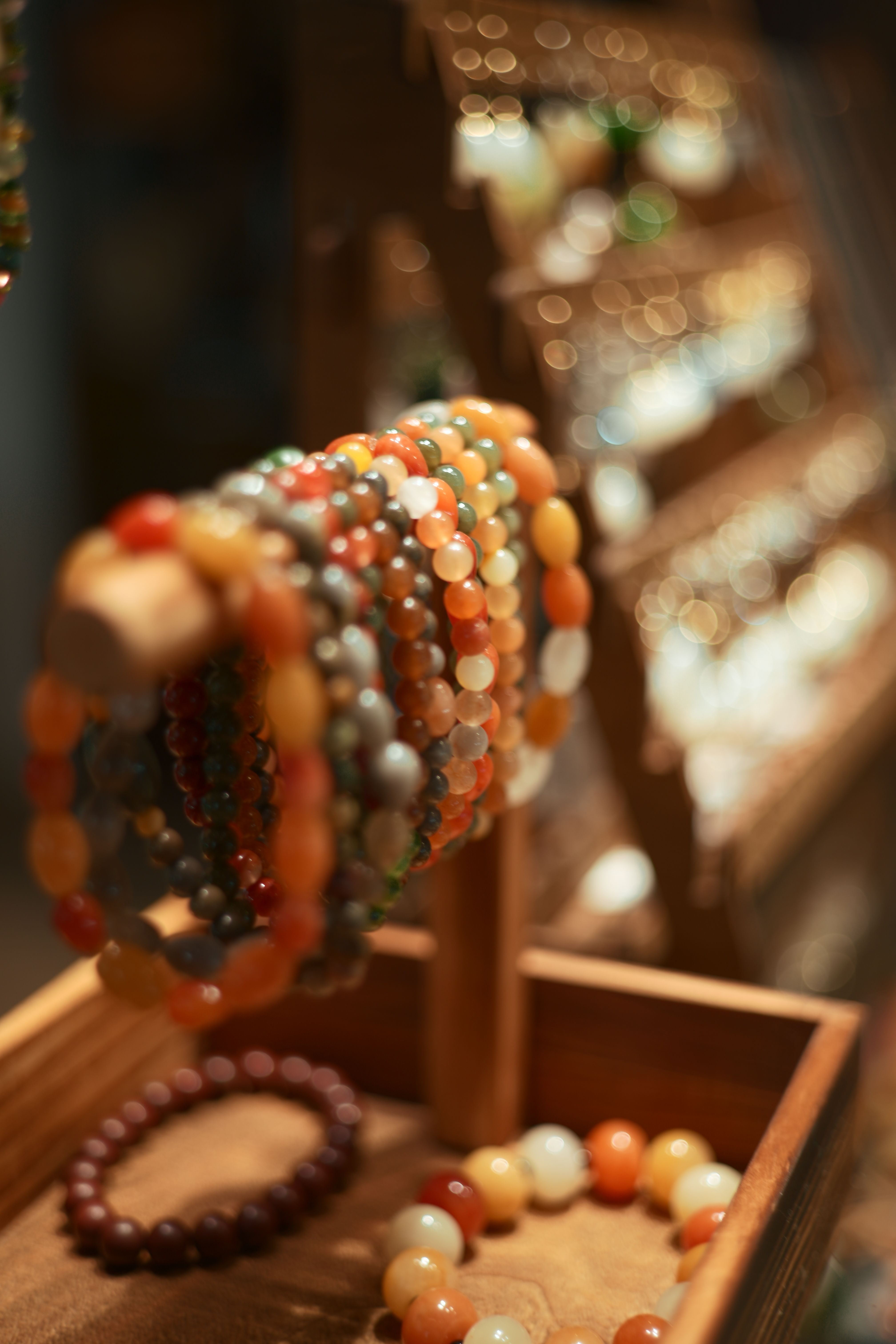 Bracelets de perles colorées sur un présentoir.