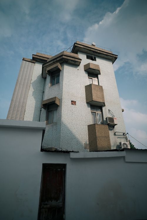 Free Modern high-rise building with unique architectural design against a blue sky backdrop. Stock Photo