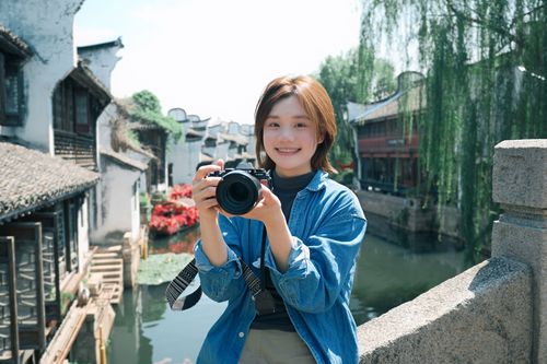 Free Smiling woman with camera on a bridge in a historic Chinese water town. Stock Photo